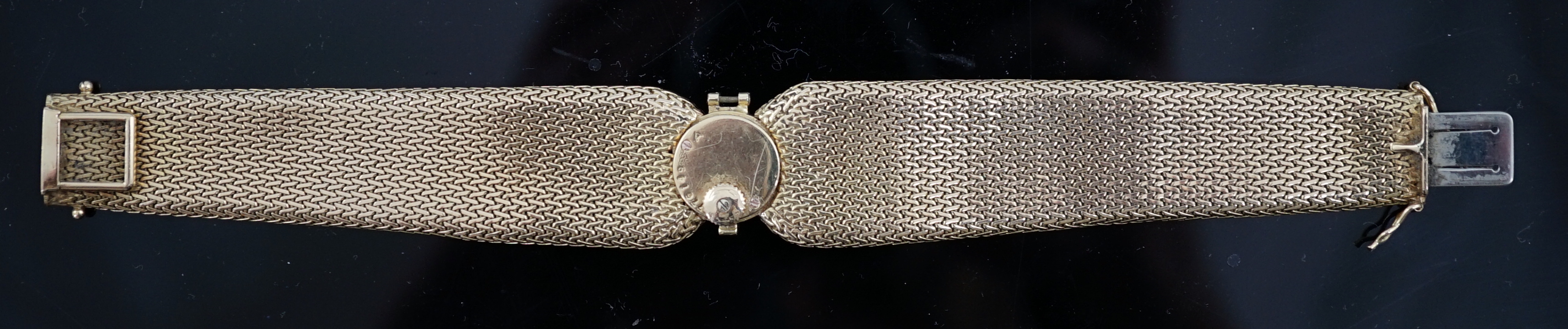 A lady's 18ct gold and eight stone diamond set manual wind cocktail, the dial inscribed Cartier, on integral tapered gold bracelet set with eight round cut stones